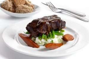 a plate of beef feather blade with fork and knife