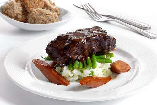 a plate of beef feather blade with fork and knife